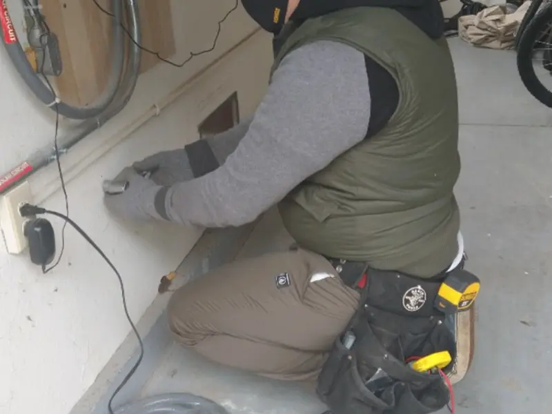 Electrician performing outlet wiring in a Midland garage
